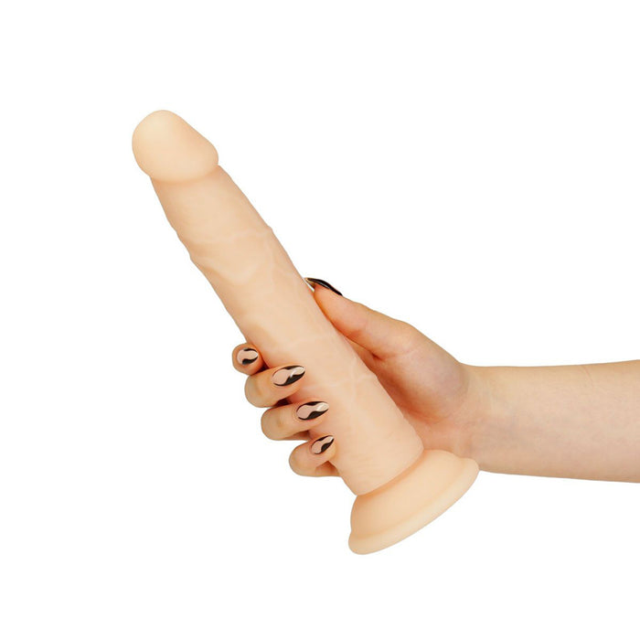 Hand holding a beige realistic-looking 9 inch silicone dildo with realistic texture and a suction cup base.