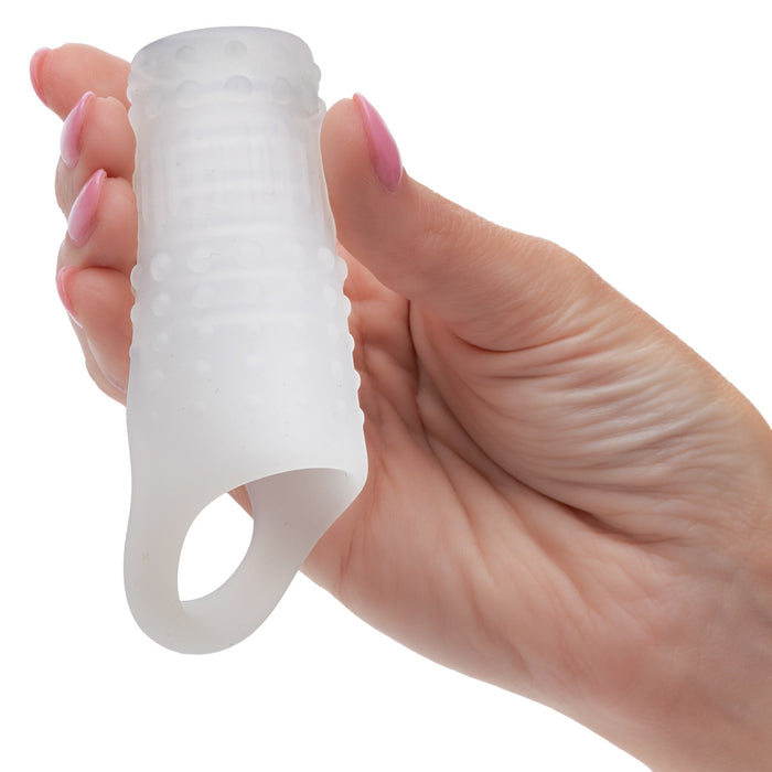 Hand holding a clear textured penis sleeve on a white background