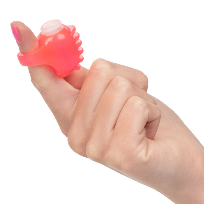 Hand wearing a pink finger vibrator on a white background