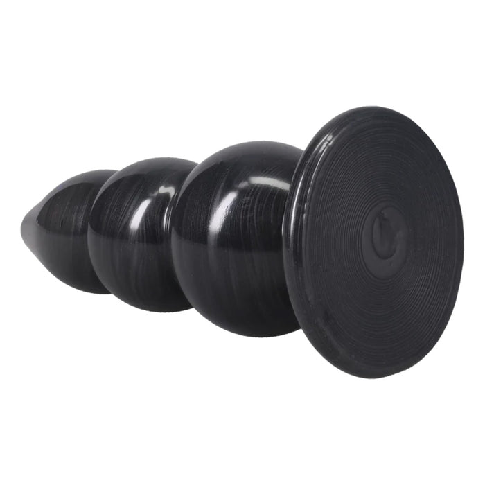 A black PVC butt plug with a flared circular base and a tapered, ribbed shaft, shown on a plain white background.