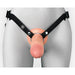 Front view of mannequin wearing a realistic beige silicone strap-on with nylon harness on a grey background